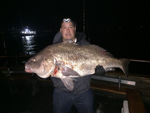 man holding large drum fish after fishing