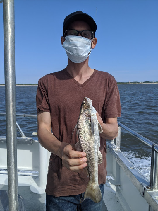 man with mask holding recently caught fish
